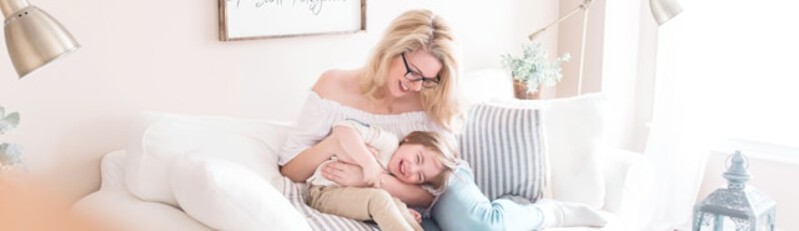 mom and child laughing on couch