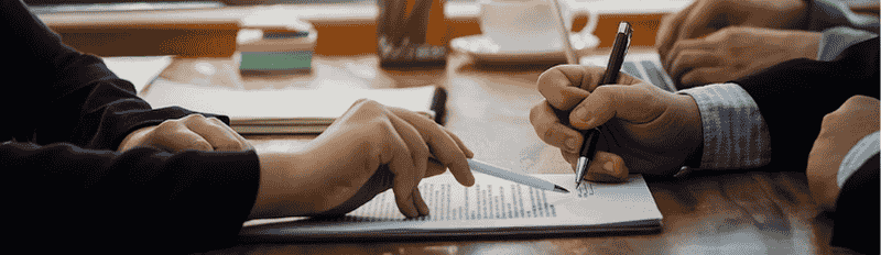 two people signing a document