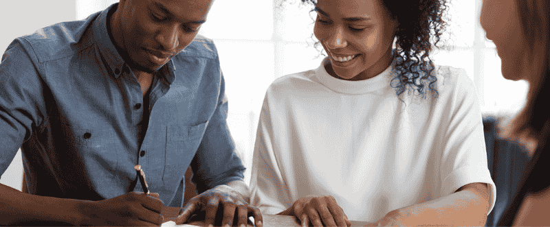 young couple signing a document