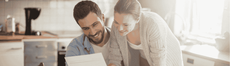 man and woman in kitchen on laptop